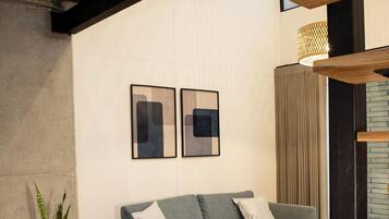 A modern living room with a grey sofa, a potted plant, and a wooden coffee table.