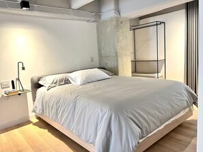 A modern bedroom with a bed, bedside table, and a built-in wardrobe. - VENTO MOLINO (BELEN)