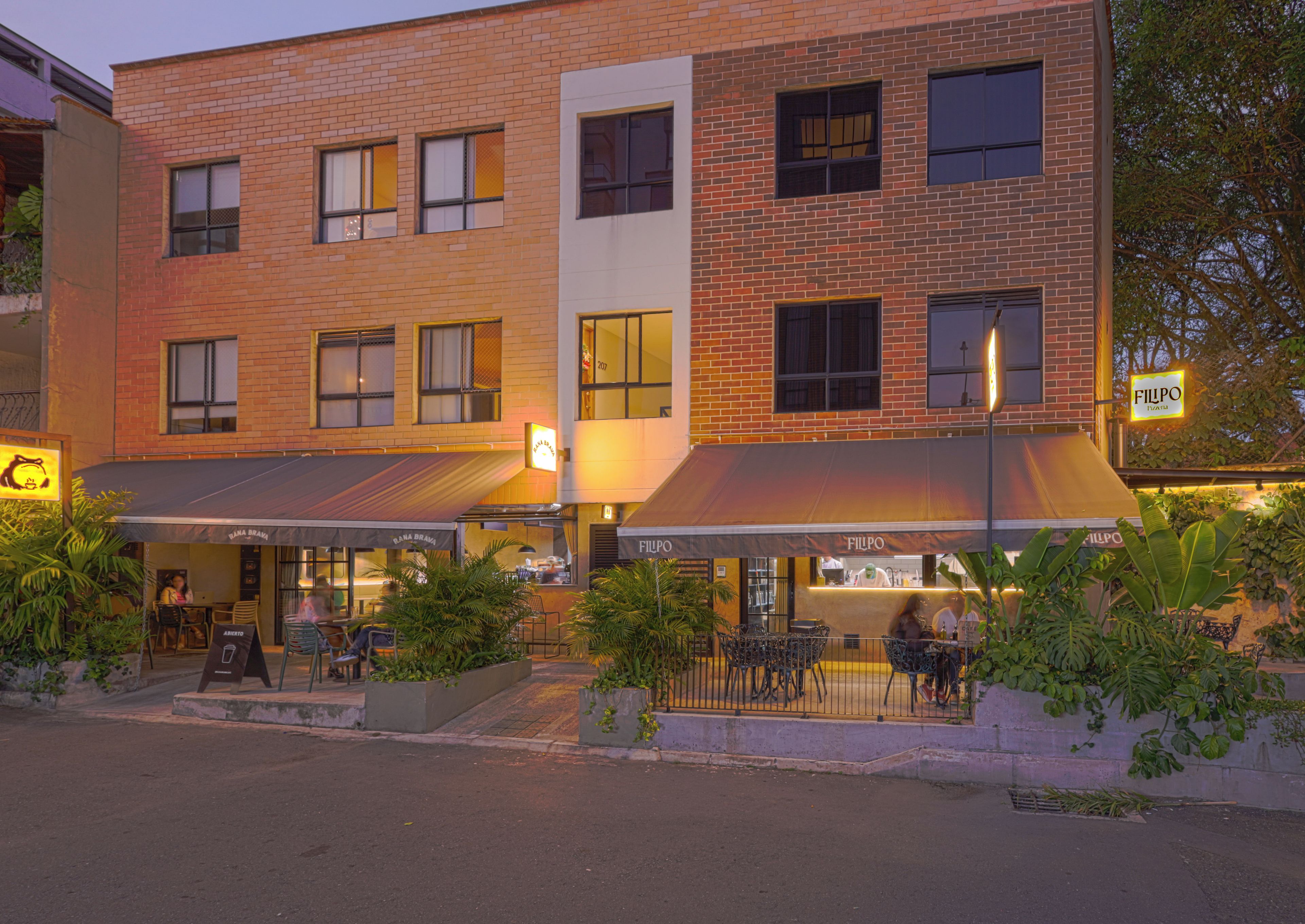 A multi-story building with outdoor seating areas and a restaurant named FILIPO.