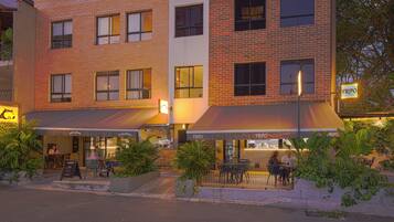 A multi-story building with outdoor seating areas and a restaurant named FILIPO.