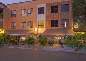 Un immeuble à plusieurs étages doté d’espaces extérieurs aménagés en terrasses et abritant un restaurant appelé FILIPO.