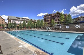 A swimming pool with clear lanes, surrounded by lounge chairs and a building with multiple floors. - Hyatt Residence Club Breckenridge, Main St Station (Breckenridge)