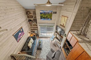 A spacious living area with a fireplace, a television, and a bookshelf. - Updated Studio in Elkhorn Village, Sun Valley (Sun Valley)