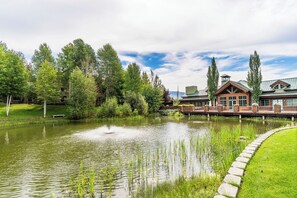 A lakeside hotel with a pond, wooden deck, and surrounding greenery. - Updated Studio in Elkhorn Village, Sun Valley (Sun Valley)