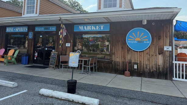 A market with a covered seating area and a sign indicating parking for curbside pickup. - Rose Haven Coastal Cottage (North Beach)