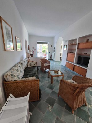 A living room with a sofa, chairs, a television, and a fireplace. - Casa Cachepot - Sweet Silvana (Ischia)