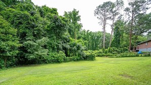 A well-maintained lawn with a hedge and trees in the background. - Stylish 5BR Retreat Near Airport & Downtown (Atlanta)