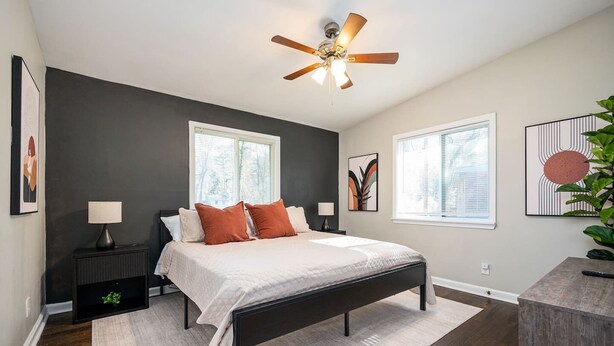 A bedroom with a bed, nightstands, a ceiling fan, and artwork on the walls. - Stylish 5BR Retreat Near Airport & Downtown (Atlanta)