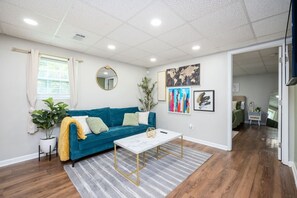 A modern living room with a blue sofa, a coffee table, and artwork on the walls.
