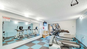 A gym with various cardio machines, a mirrored wall, and a checkered floor pattern. - Carolinian Beach Resort 1030 (Myrtle Beach)