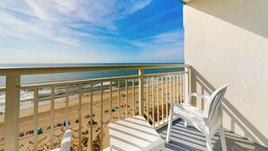 A balcony with a view of the beach, white chairs, and a table. - Carolinian Beach Resort 1030 (Myrtle Beach)