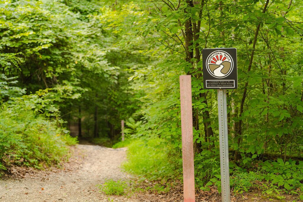 A signpost with a logo and text indicating a recreational trail.
