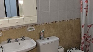 A bathroom with a toilet, bidet, and sink.
