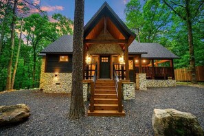 Ein Chalet mit Naturstein-Fassade, Holzeingang und befestigter Auffahrt.