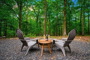 Eine Sitzecke für zwei Personen mit Tisch in bewaldeter Landschaft.