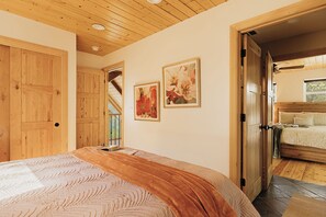 Une chambre à coucher avec un lit, des portes en bois et un escalier menant à une autre pièce.