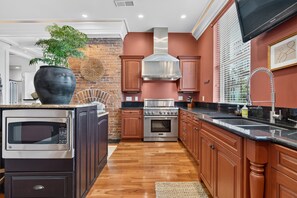 A modern kitchen with a built-in oven, microwave, and stainless steel range.