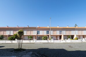 A row of modern buildings with a paved courtyard. - Casa Suave Mar (Marinhas)