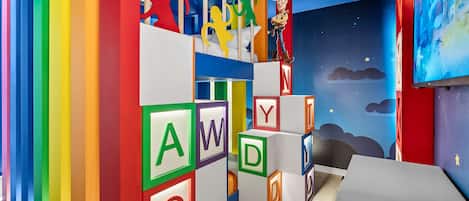 Un área de juegos infantiles con bloques del alfabeto y una figura de Woody el Guardabosques.