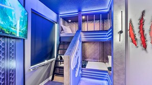 A multi-level room with bunk beds, a staircase, and a wall-mounted TV. - Luxury 8BR Themed Villa With Private Pool (Clermont)