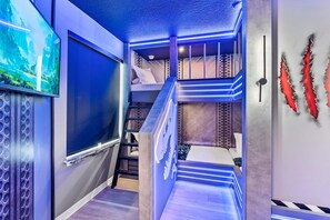 A multi-level room with bunk beds, a staircase, and a wall-mounted TV. - Luxury 8BR Themed Villa With Private Pool (Clermont)