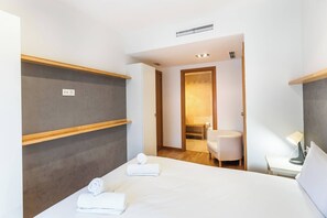 A hotel room with a bed, a small seating area, and a shower. - 6CBADR1141 Apartment near the beach &swimming pool (Barcelona)