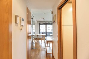 A hotel corridor with a wooden door, a reception desk, and a dining area with tables and chairs. - 6CBADR1141 Apartment near the beach &swimming pool (Barcelona)