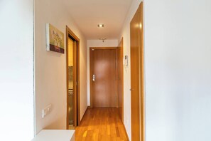 A hallway with wooden flooring, a door at the end, and a wall-mounted light fixture. - 6CBADR1141 Apartment near the beach &swimming pool (Barcelona)
