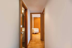 A hallway with wooden doors leading to a room with a bed and a chair. - 6CBADR1141 Apartment near the beach &swimming pool (Barcelona)