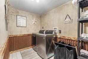 Une buanderie équipée d’un lave-linge, d’un sèche-linge et d’un étendoir.
