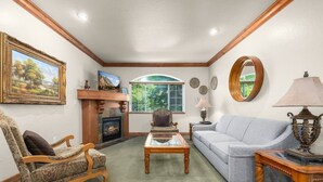 A living room with a fireplace, a sofa, a chair, and a coffee table. - Swiss Mountain Escape | Pool | Hot Tub | Tennis (Midway)