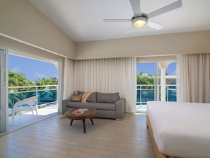 A hotel room with a balcony, a sofa, a coffee table, and a bed. - VIP COFRESI BEACH STUDIO ROOM ONLY (Puerto Plata)