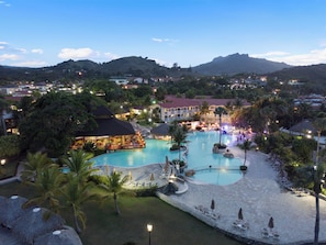 Un resort con una amplia piscina, zonas de descanso y un bar.