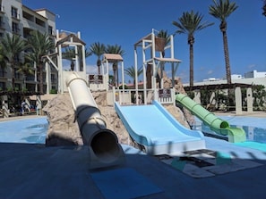 A water park with slides, palm trees, and a pool. - VIP COFRESI BEACH STUDIO ROOM ONLY (Puerto Plata)