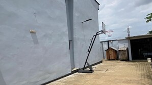 Ein Gebäude mit flachem Dach, einer Tür und einem Basketballkorb.