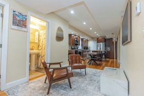 A modern kitchen with dark wood cabinets, stainless steel appliances, and a marble countertop. - Stylish 3BEDROOM 2 BATH Home Near Boston Sleeps 9 (Medford)