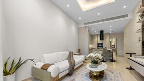 Ein stilvolles Wohnzimmer mit einem weißen Sofa, einem Couchtisch und einem gemusterten Teppich.