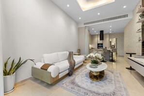 Ein stilvolles Wohnzimmer mit einem weißen Sofa, einem Couchtisch und einem gemusterten Teppich.