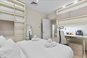 Ein Hotelzimmer mit Bett, Schreibtisch und Stuhl. Auf dem Bett liegen Handtücher.