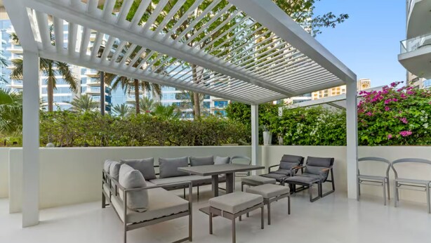 Eine Terrasse im Freien mit einer Pergola, einer Sitzgelegenheit und Blick auf die Stadt.