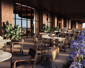 An outdoor seating area with brick walls, large windows, and potted plants. - Fasano Peninsula (Punta del Este)