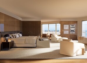 A modern hotel room with a large bed, a sofa, a chair, and a view of the city. - Fasano Peninsula (Punta del Este)