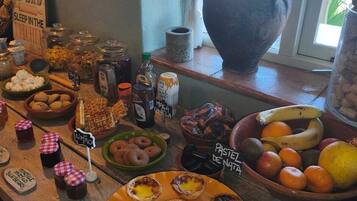 Un bufé de desayuno con diversos alimentos y un cartel que indica que el desayuno se sirve en la habitación.