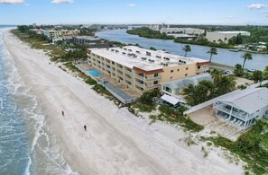 A beachfront hotel with multiple floors, a swimming pool, and a view of the ocean and river. - Excellent 1-bedroom 1-bath condo with AC in Indian Rocks Beach (Indian Rocks Beach)