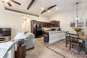A modern kitchen with dark wooden cabinets, a black refrigerator, and a microwave. - Beautiful 3 bed 2 bath property with 2 car garage (Wichita)