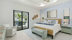 Ein modernes Schlafzimmer mit einem großen Bett, einer Sitzecke und Blick ins Freie.