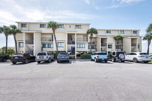 A multi-story building with a parking lot in front. - Santa Rosa Dunes 321 (Pensacola Beach)