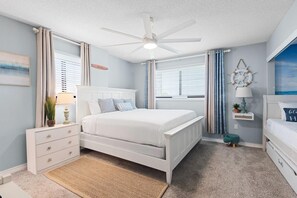 A bedroom with a bed, a nightstand, a dresser, a ceiling fan, and a window with curtains. - Santa Rosa Dunes 321 (Pensacola Beach)