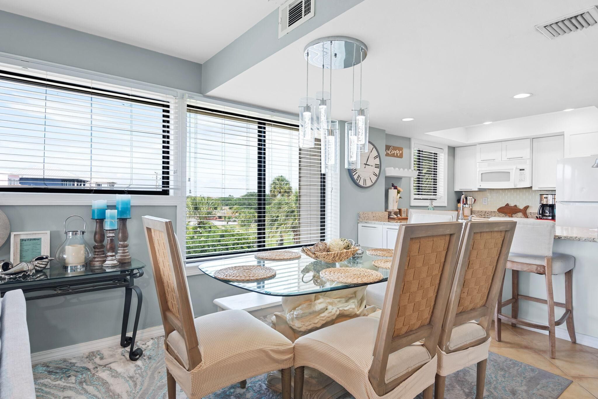 A modern kitchen with white cabinets, a microwave, and a refrigerator.