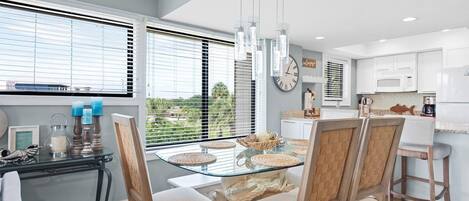 A modern kitchen with white cabinets, a microwave, and a refrigerator.